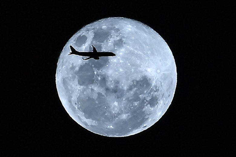 A plane in flight is silhouetted against the 'super blue moon' over Cali, Colombia on January 31, 2018.